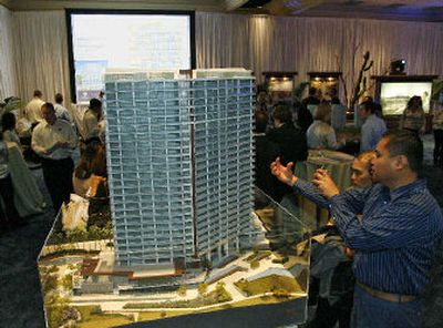 
Prospective buyers Ramon Tumanan, far right, and Ed Solver, right, look over a model of the first phase of the Trump Ocean Resort Baja Mexico during a sale at Manchester Grand Hyatt in San Diego Friday.
 (Associated Press / The Spokesman-Review)