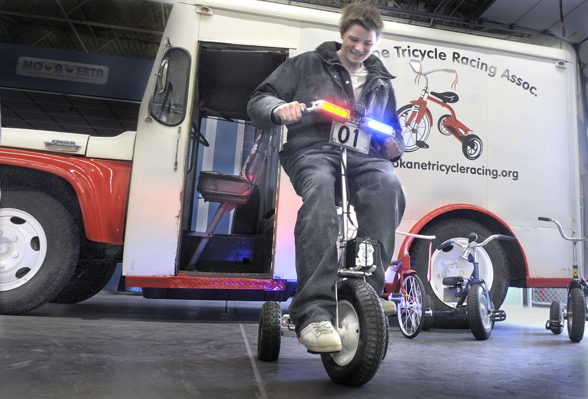 Spokane Skills Center student Josh Pegram tries out the tricycle built in the style of a police vehicle with lights, badges and siren.  (CHRISTOPHER ANDERSON / The Spokesman-Review)
