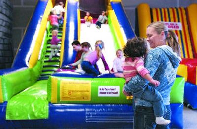 
Kelly Richardson and her niece, Bella, watch as children bounce on the inflatable slide during the open jump at Jump and Bounce in Spokane Valley. 