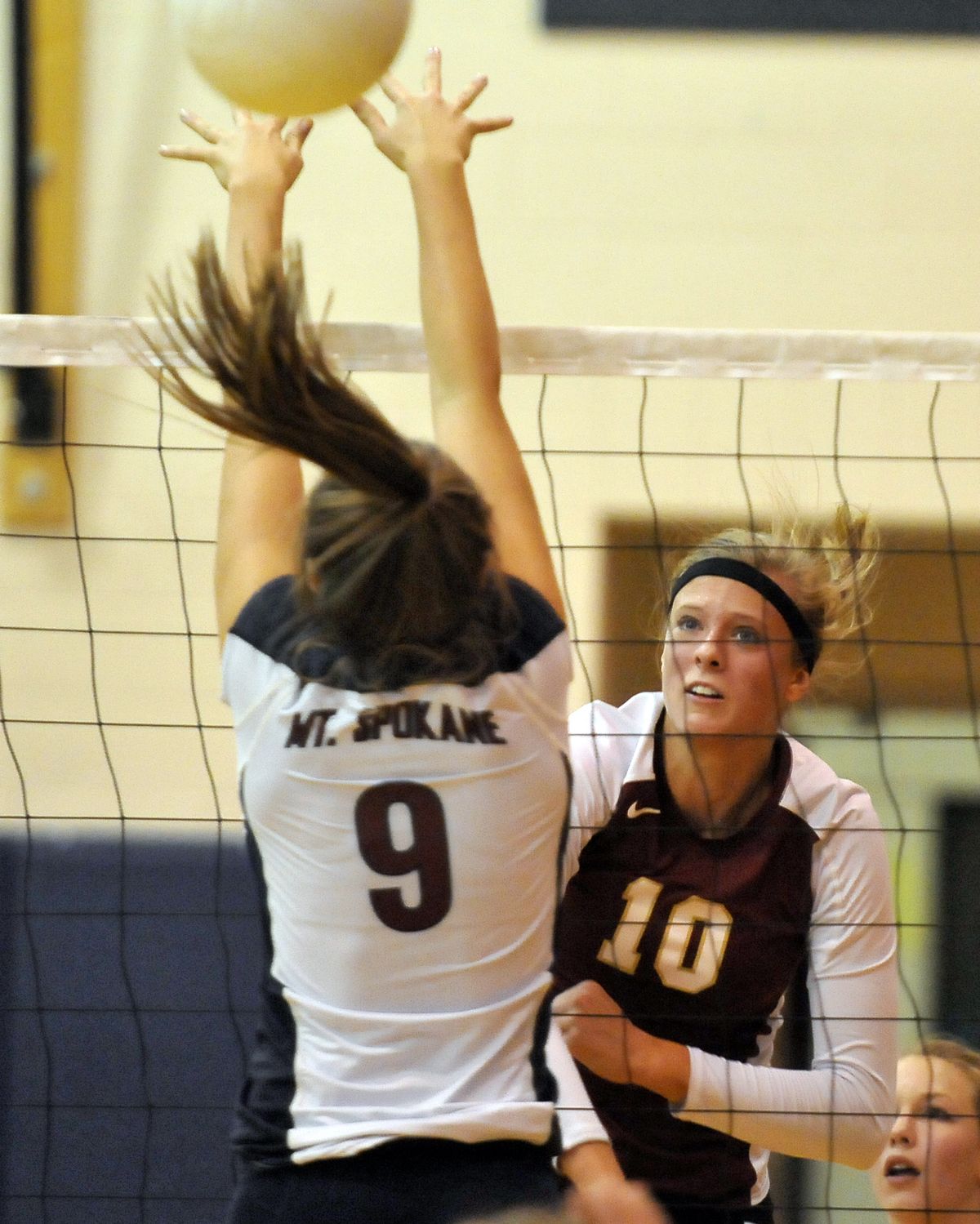 U-Hi’s Kayleigh Valley (10) watches her spike sail between the hands of Mt. Spokane’s Lexi Hereford. (Jesse Tinsley)
