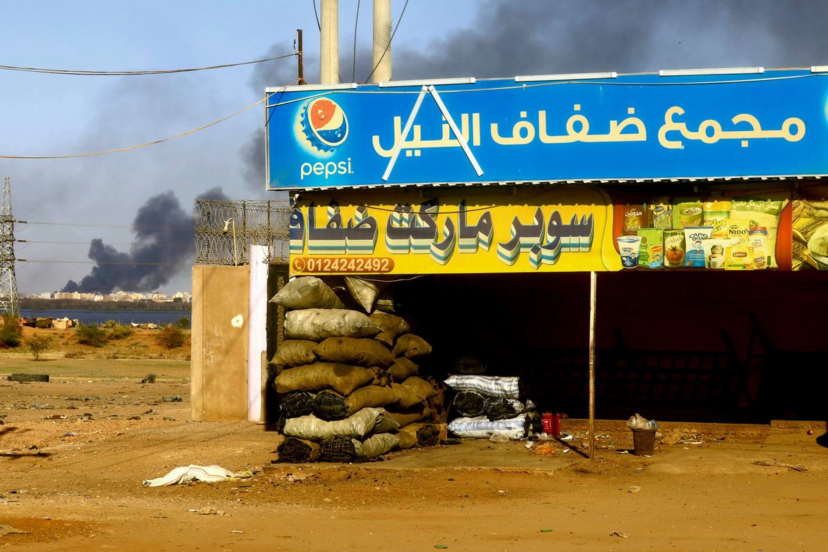 Acrid smoke rises over a closed shop on April 19, 2023, in Khartoum, Sudan, as U.N. agencies express concern over the effect of fighting on civilians in the war-torn country.   (Mohamed Khidir/Xinhua)