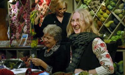 
Peggy Appleman, right, shows off her latest creation, a green knitted scarf, during the 