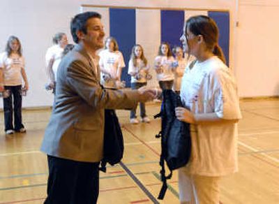 
Josh Allison of Horizon Credit Union presents Kayla Quass with a backpack during Thursday's assembly.
 (The Spokesman-Review)