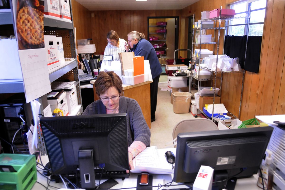 Valley Mission Homecare Pharmacy staff members work Tuesday in a temporary trailer, which is adjacent to their fire-damaged building. (PHOTOS BY J. BART RAYNIAK)