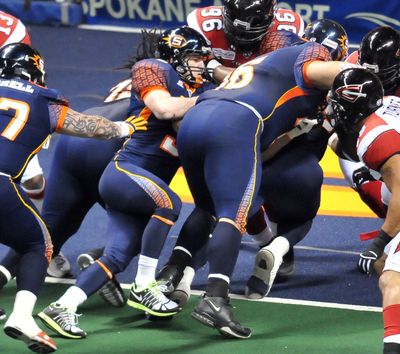Spokane Shock's quarterback, Kyle Rowley, center, facing right, falls in behind his defense on the quarterback keeper to score a touchdown against the Cleveland Gladiators on Saturday, March 19, 2011, at the Spokane Arena. (Jesse Tinsley / The Spokesman-Review)