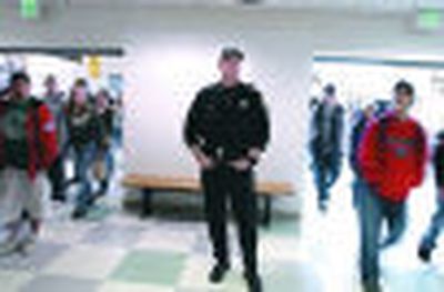 
School resource Deputy Scott Kenoyer  waits for the second-lunch students at East Valley High School's cafeteria on Tuesday. 
 (J. Bart Rayniak / The Spokesman-Review)