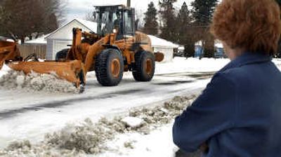 
Barbara Lawrence of Coeur d'Alene watches as a snow plow clears her street on Jan. 3. 
 (Kathy Plonka / The Spokesman-Review)