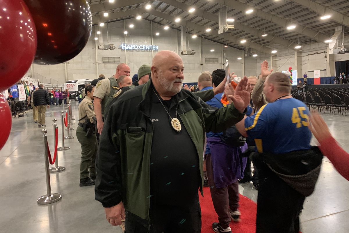 Kalispel Tribal Police Officer Jay Hughes, a longtime volunteer for the Special Olympics Washington, high-fives athletes during the 2019 State Fall Games at the HAPO Center in Pasco.  (Courtesy of the Special Olympics Washington)