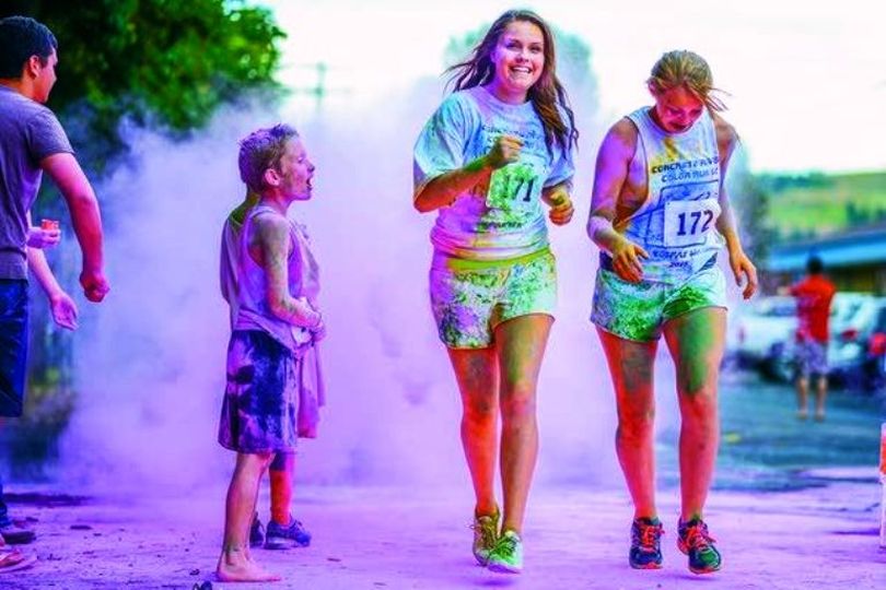 A runner in the 2015 Concrete River Color Run sprints though clouds of colored powder Saturday in Colfax. (Nathan Howard / Moscow-Pullman Daily News)