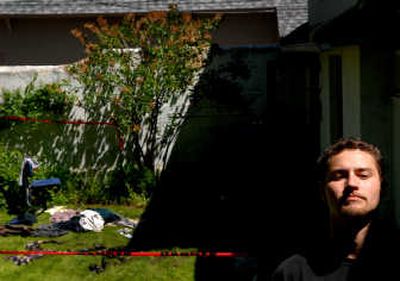 
Ross Boatsman, 24, stands  near the debris-strewn yard of a South Hill apartment destroyed by fire Monday. 
 (Brian Plonka / The Spokesman-Review)