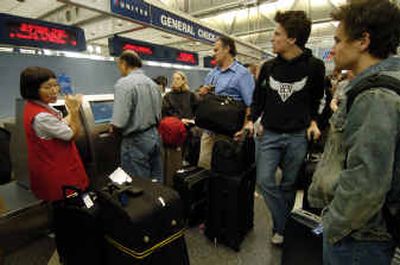 
A United Airlines customer service clerk assists travelers at Chicago O'Hare International Airport on Wednesday.
 (Associated Press / The Spokesman-Review)