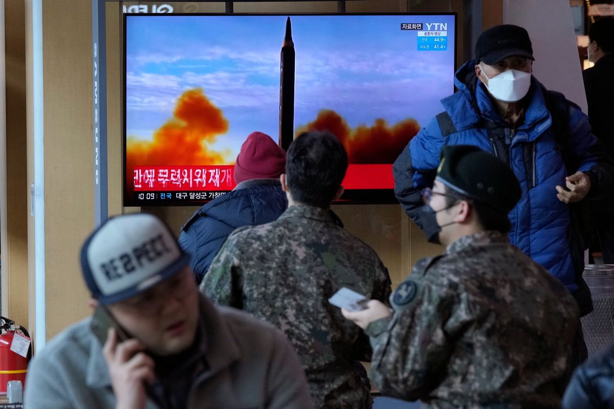 People watch a TV showing a file image of North Korea