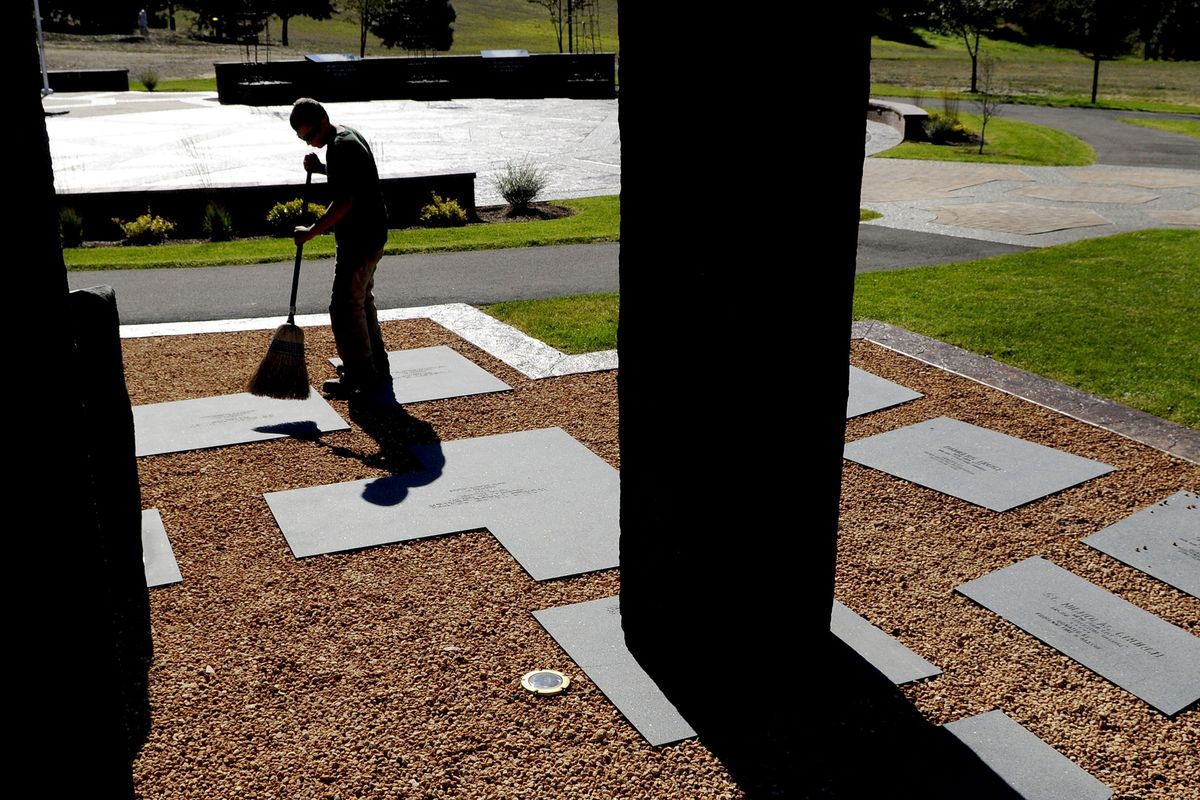 Mike Lujan, of the Coeur d’Alene Parks Department, sweeps debris from the Fallen Heroes Memorial Plaza at Cherry Hill Park on Thursday. (Kathy Plonka / The Spokesman-Review)