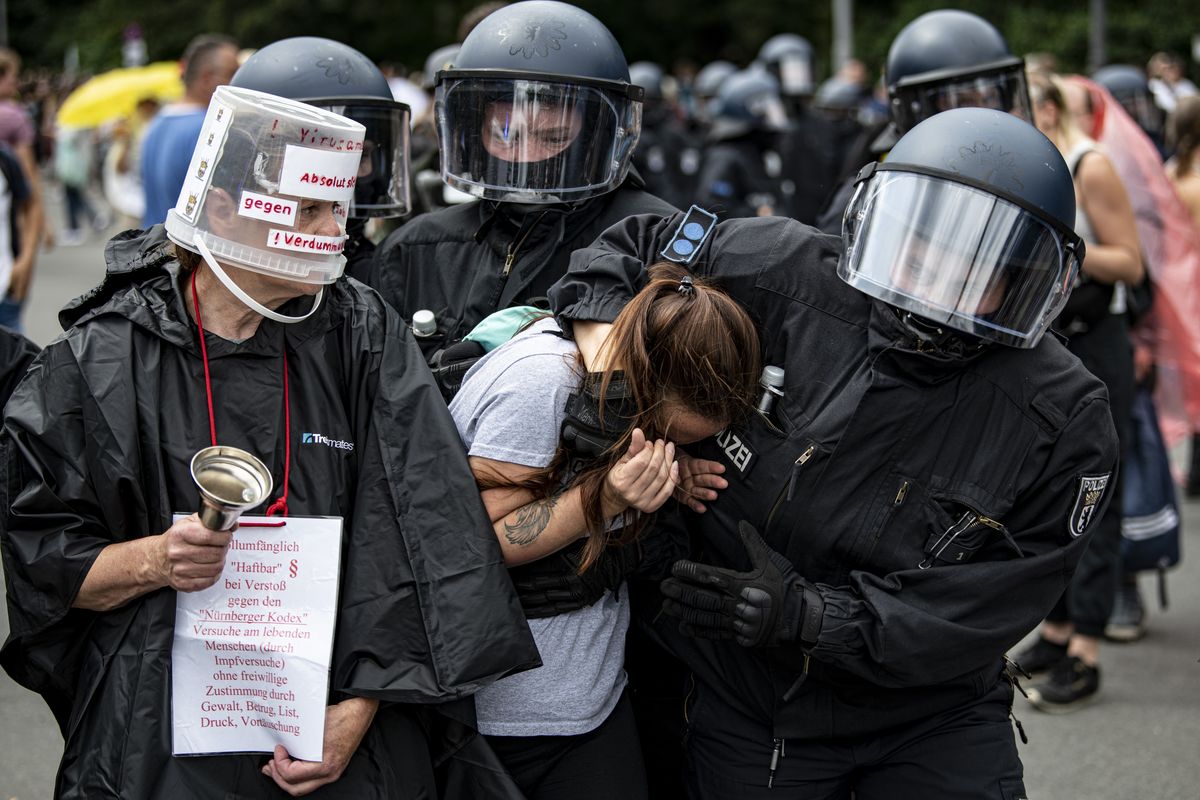 Police arrest a demonstrator at an unannounced demonstration at the Victory Column, in Berlin, Sunday Aug. 1, 2021, during a protest against coronavirus restrictions. Hundreds have turned out in Berlin to protest the German government’s anti-coronavirus measures despite a ban on the gatherings, leading to arrests and clashes with police.  (Fabian Sommer)