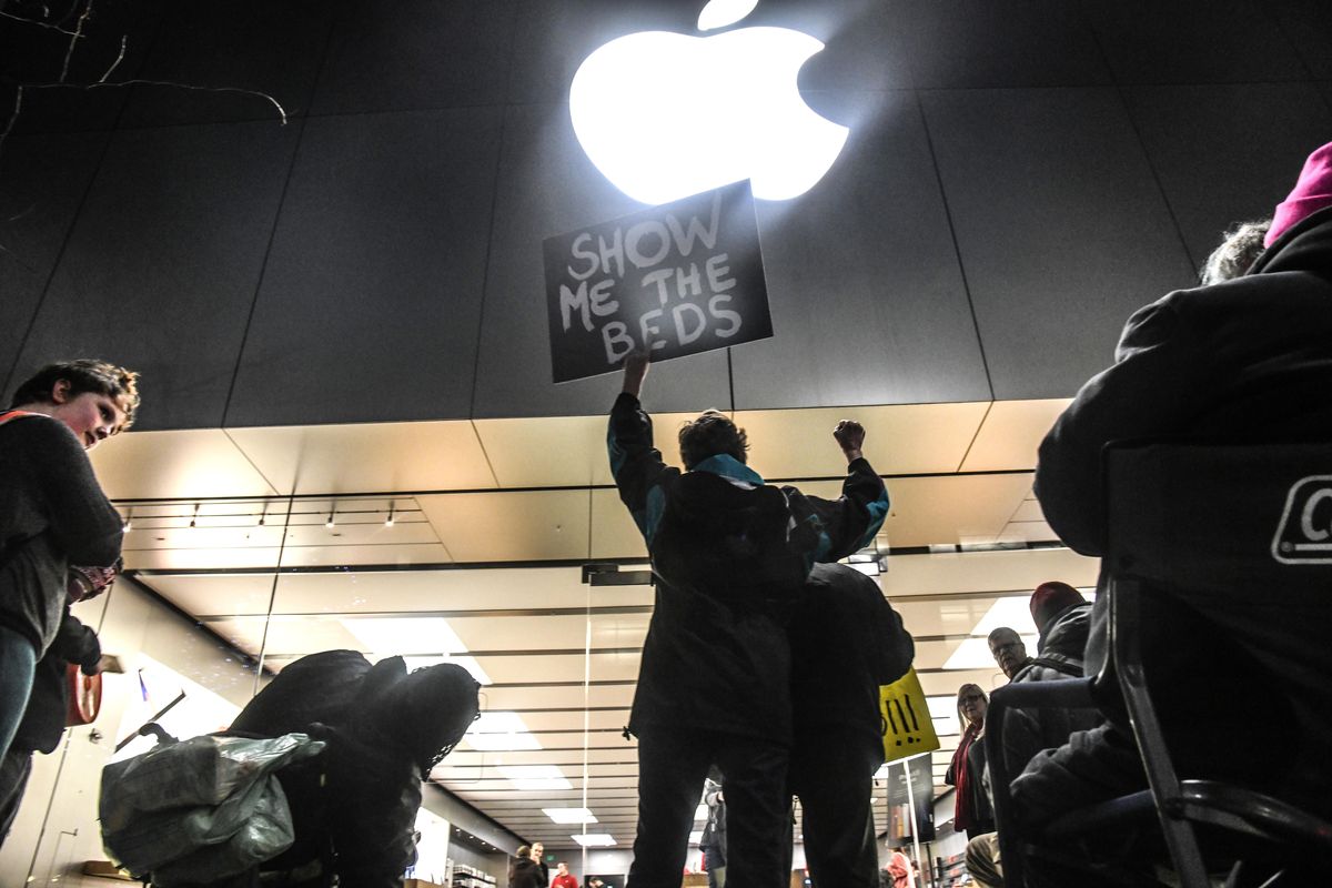 Deb Maier pumps her fist during a homeless protest outside the Apple Store, Wednesday, Dec. 19, 2018, in downtown Spokane. (Dan Pelle / The Spokesman-Review)