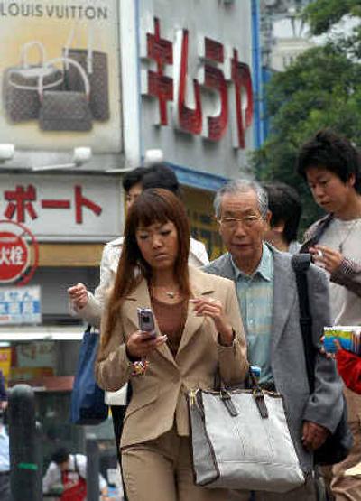 
People walk in front of a discount shop in Yokohama, south of Tokyo, Wednesday. Japan's economy grew 1.5 percent in the January-March quarter from the previous quarter, the government said Wednesday, revising figures to show slightly faster growth than initially estimated. 
 (Associated Press / The Spokesman-Review)