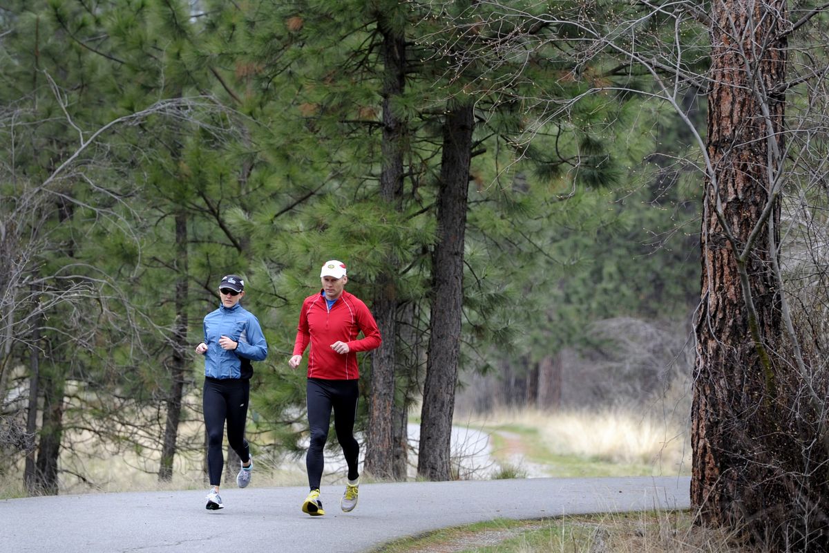 Rachel and Eric Johnson jog down the Centennial Trail in Spokane Valley in preparation for an Ironman race. (Jesse Tinsley)