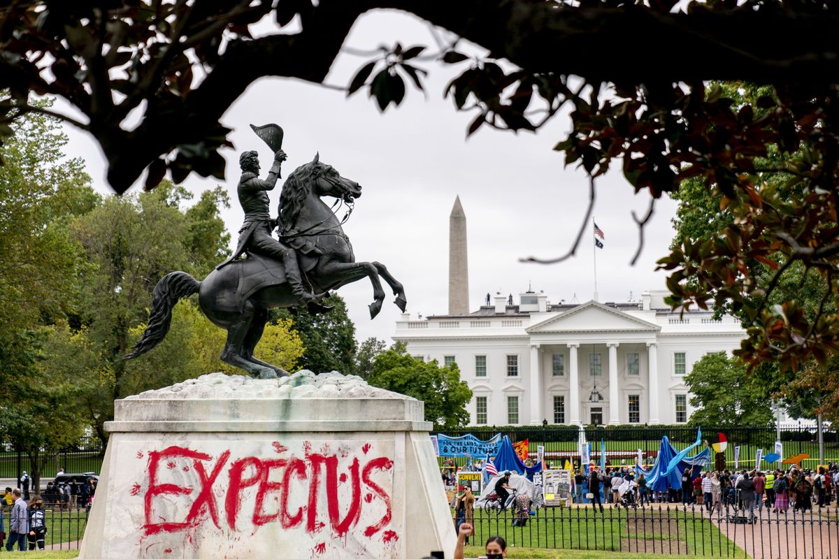 The words “Expect Us” are spray painted on the base of the Andrew Jackson statue in Lafayette Park as Indigenous and environmental activists protest in front of the White House in Washington, Monday, Oct. 11, 2021. The words are part of the phrase “Respect Us, or Expect Us” which indigenous women have been using while protesting oil company Enbridge’s Line 3 pipeline through Minnesota. President Joe Biden on Friday issued the first-ever presidential proclamation of Indigenous Peoples Day, lending the most significant boost yet to efforts to refocus the federal holiday celebrating Christopher Columbus toward an appreciation of Native peoples.  (Andrew Harnik)