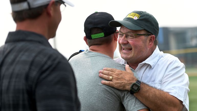 Retired Shadle Park baseball coach Ron Brooks, right, is greeted by Aaron Hancock and Tim Amann, both players from the Highlanders’ 1995 team, during his retirement party at Al Jackson Field on Friday. (Kathy Plonka)