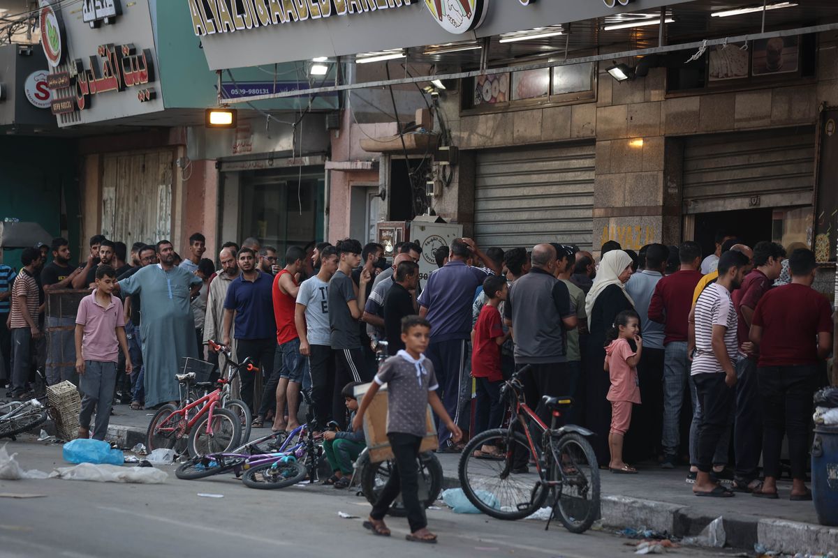 Palestinian citizens gather in front of a bakery to buy bread after suffering from power outages and food shortages due to Israeli raids in Khan Younis on Friday. MUST CREDIT: Washington Post photo by Loay Ayyoub  (Loay Ayyoub/For The Washington Post)