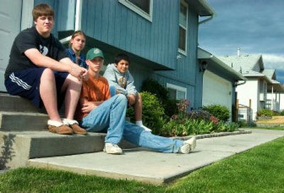 
From left, Brian, 17; Brittney, 15; Buddy, 14; and Benjamin Brand, 11, sit in front of their house Monday. Their parents bought the house  so all of their children could be in the Mead system throughout their school years. 