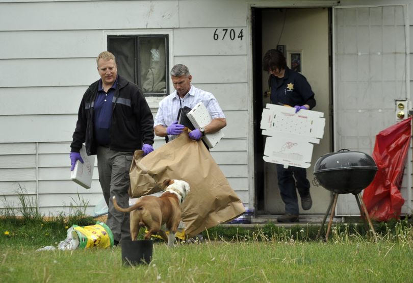 Detective Michael Drapeau (front) and investigators with the Spokane County Sheriff's Office remove evidence from a house at 6704 E. Third Ave. Shane Caleb Smith, 38, was arrested there this afternoon in connection with the homicide of Warren Flinn in Spokane Valley. (Colin Mulvany / The Spokesman-Review)