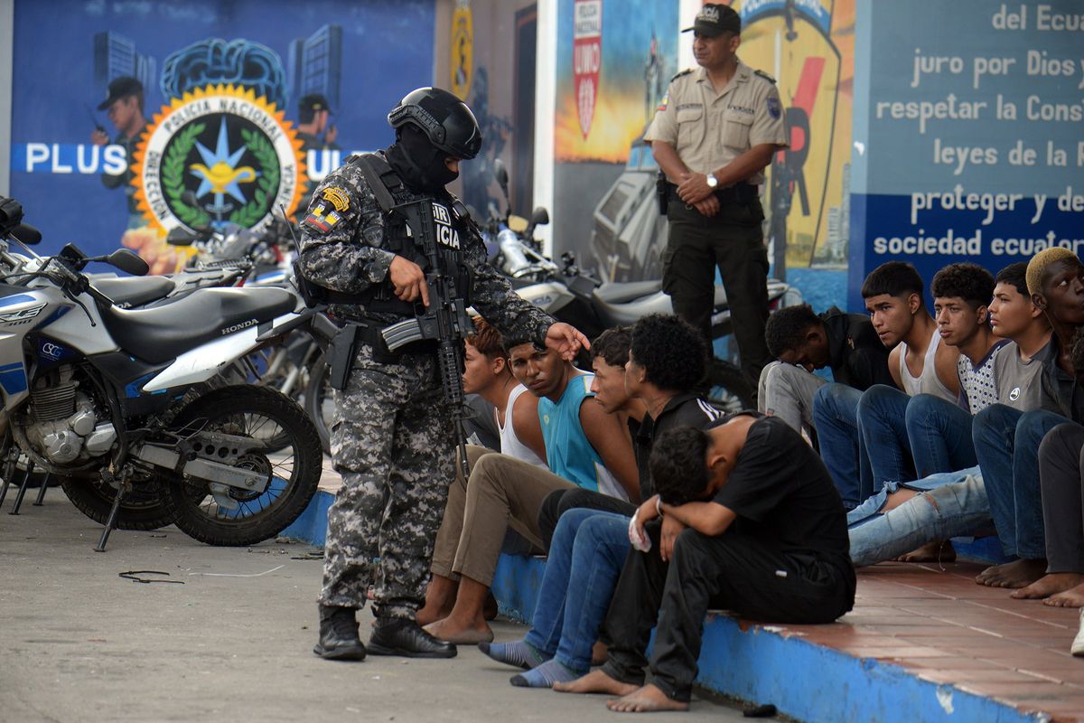 Police present detainees in the case of TC Televisión on Wednesday in Guayaquil, Ecuador. President Daniel Noboa declared “internal armed conflict” after hooded and armed men broke into TC Television’s live broadcast, among other violent incidents across the country on Tuesday. Ecuador has been hit by explosions, police kidnappings, and prison disturbances since Noboa on Monday declared a nationwide state of emergency after gang leader Adolfo “Fito” Macias escaped from a prison in Guayaquil.  (Getty Images)