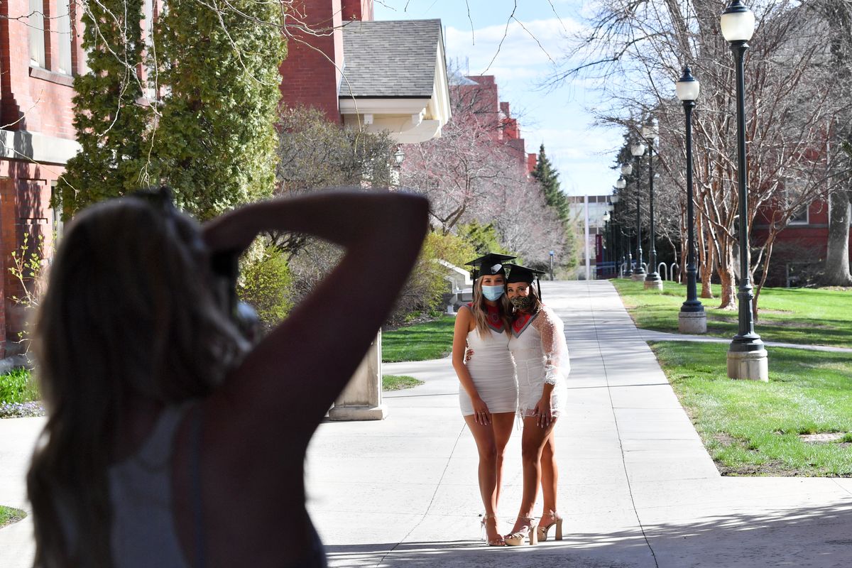 Mackenzie Monson, left, and Natalie Przybylski, best friends and soon-to-graduate WSU seniors pose for senior portraits with Brittney Kluse, a Tri-Cities-based photographer, Thursday on WSU’s campus in Pullman. Both women lamented not being able to walk at graduation due to COVID-19 regulations.  (Tyler Tjomsland/The Spokesman-Review)