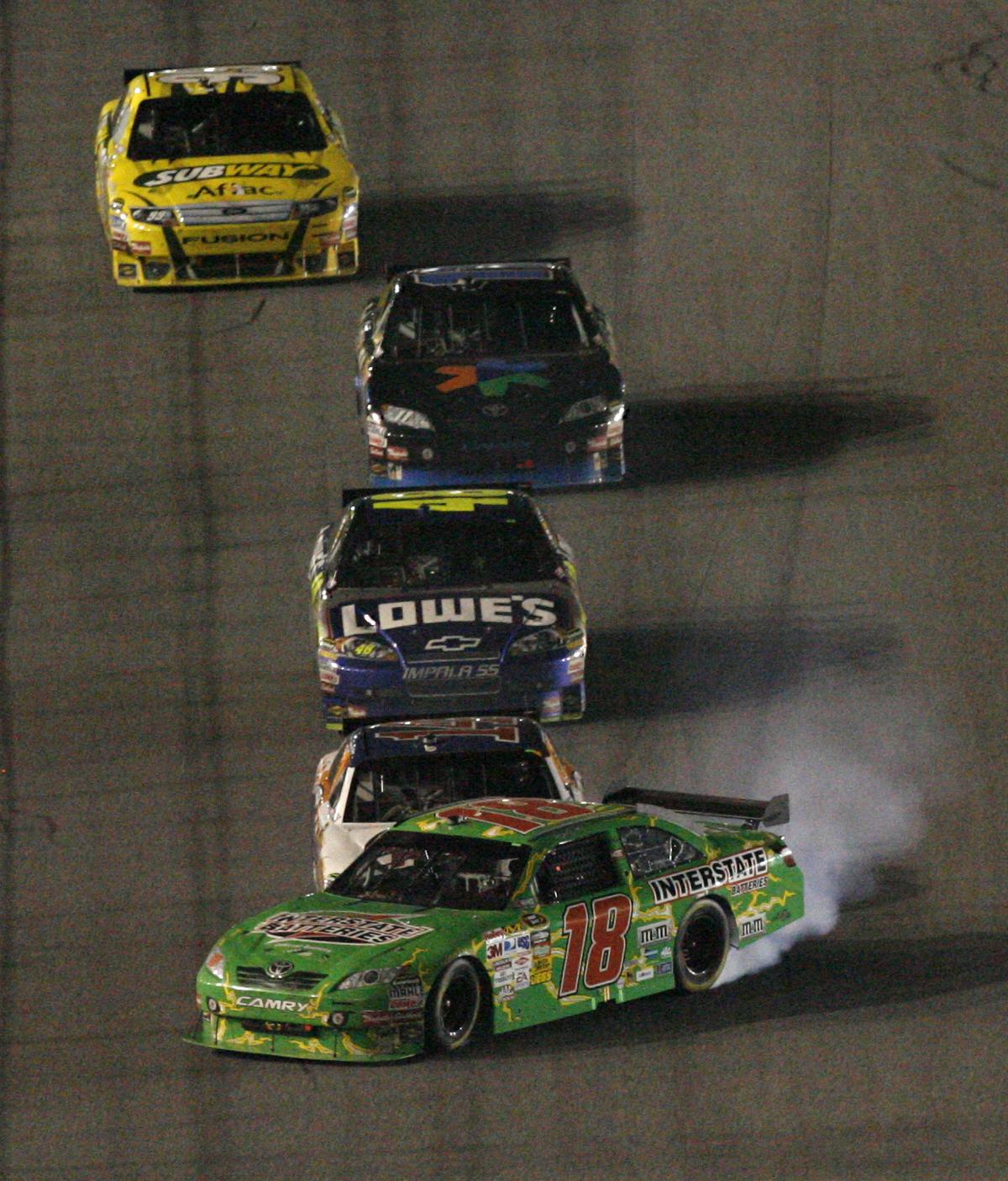 Kyle Busch (18) slides toward the wall after contact with Tony Stewart’s car on last lap. (Associated Press / The Spokesman-Review)
