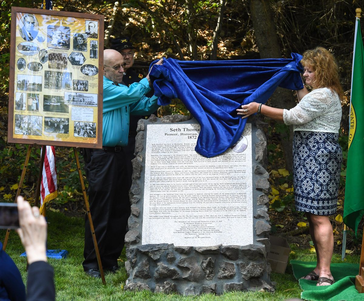 Don Bartleson, grandson of Seth Woodard, left, and Sheila Brown, great granddaughter of Seth Woodard, unveil a historic monument to Woodard, a pioneer, historian and philanthropist, during a ceremony, Friday, Sept, 14, 2018, at Greenwood Memorial Terrace, in Spokane, Wash. (Dan Pelle / The Spokesman-Review)