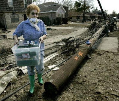 
Geneva Landry carries items to a car as she helps a friend salvage items from her flood-damaged home in the Lakeview area of New Orleans Wednesday. 
 (AP / The Spokesman-Review)
