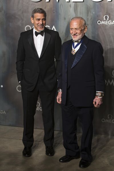 Actor George Clooney, left, and former astronaut Buzz Aldrin pose for photographers upon arrival at the party being held for the 60th anniversary of the Omega Speedster watch in London, Wednesday, April 26, 2017. (Grant Pollard / Associated Press)
