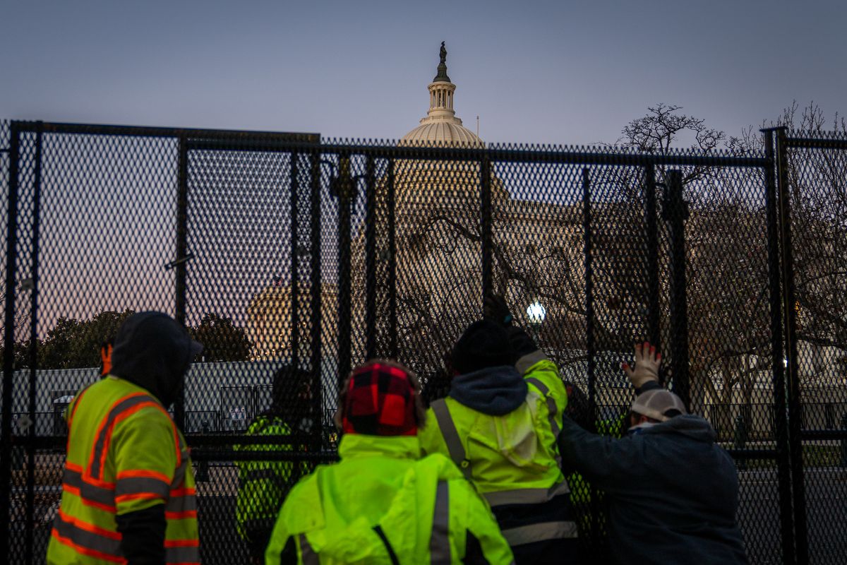 Workers install fences outside the U.S. Capitol on Saturday.  (Allison Robbert/For The Washington Post)