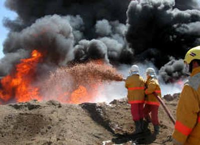 
Firefighters try to contain an oil-pipeline fire after an attack by insurgents near Beiji, north of Baghdad, that left much of the country without power Tuesday. 
 (Associated Press / The Spokesman-Review)