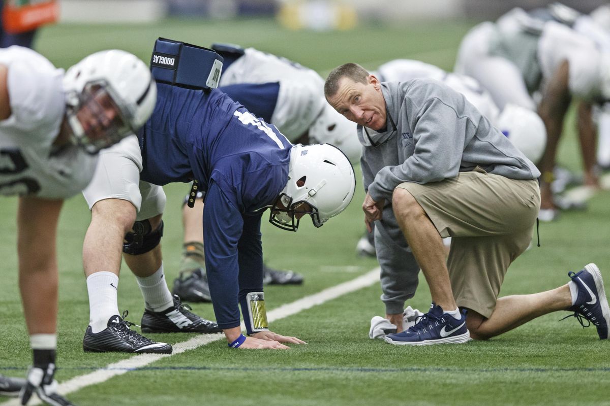 In this March 23, 2015, photo, Penn State athletic trainer Tim Bream, right, talks with quarterback Christian Hackenberg, in blue, as he stretches during an NCAA college spring football practice in State College, Pa. (Joe Hermitt / Associated Press)