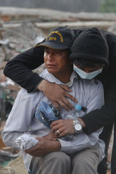 A Nepalese man consoles his friend after rescue workers found the body of his son in the rubble of his house in Kathmandu, Nepal, Wednesday. A massive earthquake struck the capital region Saturday. (Associated Press)