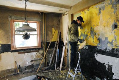 
Joe Sumerlin of Frick & Frack Painting and Reconditioning steams and peels several layers of wallpaper in the kitchen as part of an effort to restore a 100-year-old Julius M. Dutton house on west Sharp Avenue in Spokane. 
 (Photos by Dan Pelle / The Spokesman-Review)