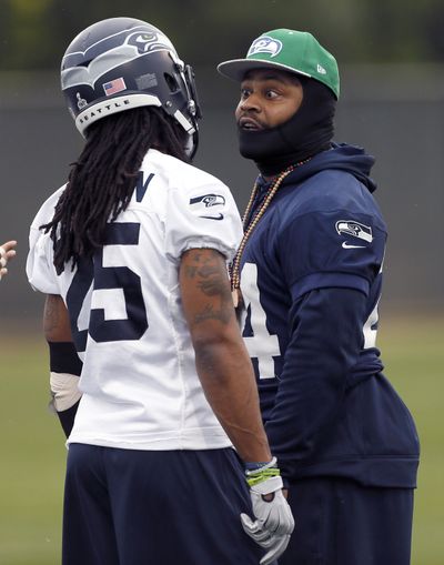 Seattle Seahawks’ Marshawn Lynch, right, talks with Richard Sherman during a team practice on Thursday. (Associated Press)