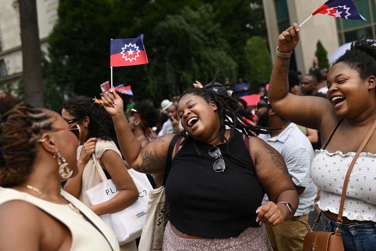 Sydnee Martin, left, dances and sings with Trianna Downing, center, and her twin sister, Morgan Downing, during Juneteenth celebrations in 2019 at Black Lives Matter Plaza in Washington, D.C.  (Matt McClain/The Washington Post)