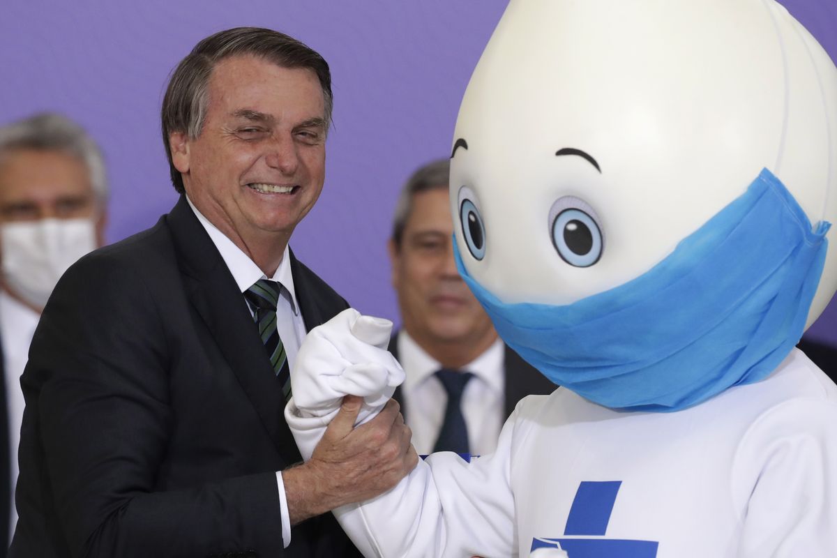 Brazilian President Jair Bolsonaro poses for photos with the mascot of his nation