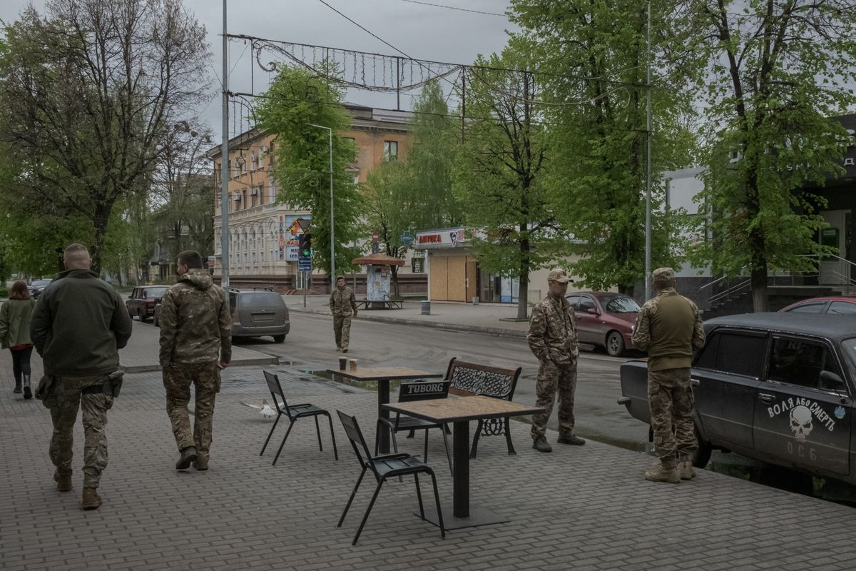 Ukrainian soldiers talk to each other near a cafe in central Slovyansk, Ukraine, April 25, 2023. In a battered Ukrainian city, the war has stolen the normal experiences of teenage life with youths mostly using humor to deal with the ferocity of the fighting around them. (Mauricio Lima/The New York Times)  (MAURICIO LIMA)