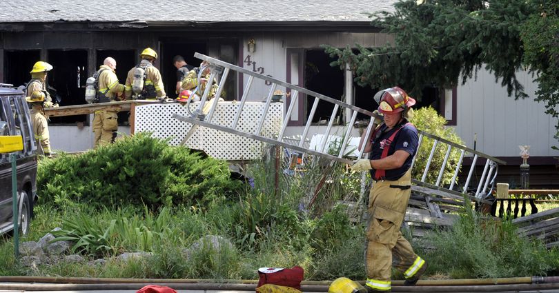 Spokane firefighters mop up a blaze that killed a woman at 4128 E. Princeton, July 15, 2011, in Spokane, Wash. (Dan Pelle / The Spokesman-Review)