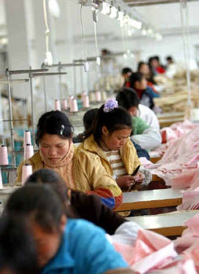 
 Chinese workers sew textiles at a garment factory in Jiaxin, Zhejiang Province, western China. 
 (Associated Press / The Spokesman-Review)