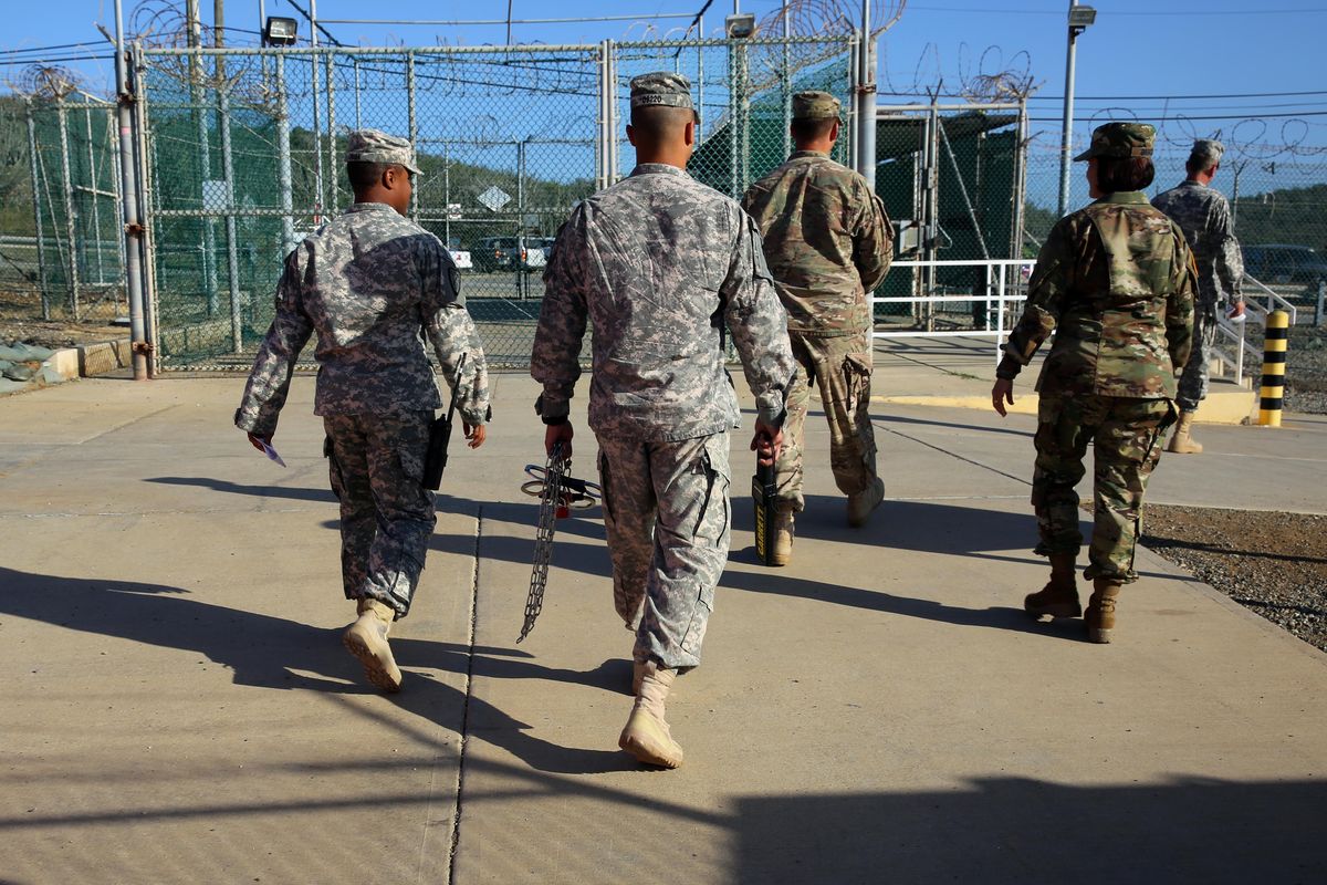 In this Feb. 2 photo, military guards exit an area known as Camp Delta at the Guantanamo Bay detention center in Cuba. (Ben Fox / Associated Press)