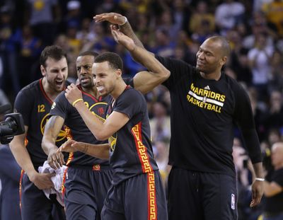 Golden State’s Stephen Curry, right, celebrates win over Spurs. (Associated Press)