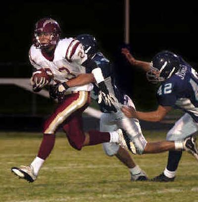 Blake Kenworty (23) and the University Titans could not escape T-Wolves defenders during a 31-7 loss to Lake City. 
 (Tom Davenport/ / The Spokesman-Review)