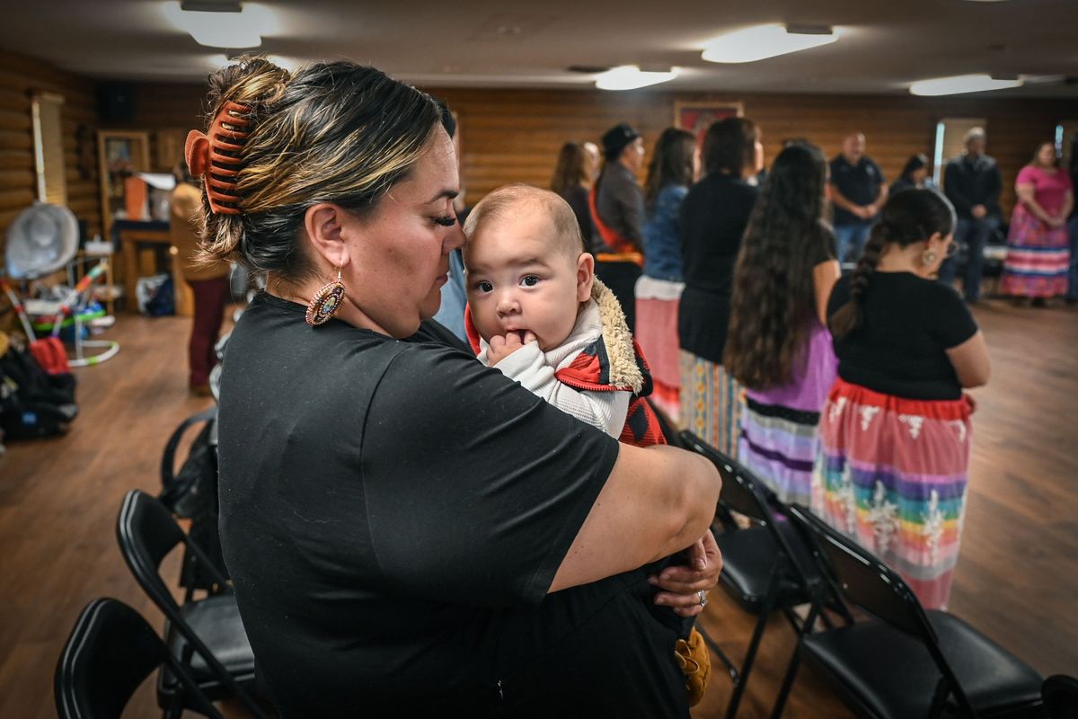 Salish language student Amelia Mendoza holds her 4-month-old son Jalen, during the inaugural ceremony for the pilot language program on Monday at the Wellpinit Longhouse. Mendoza hopes the first words the baby speaks will be in Salish.  (DAN PELLE/THE SPOKESMAN-REVIEW)