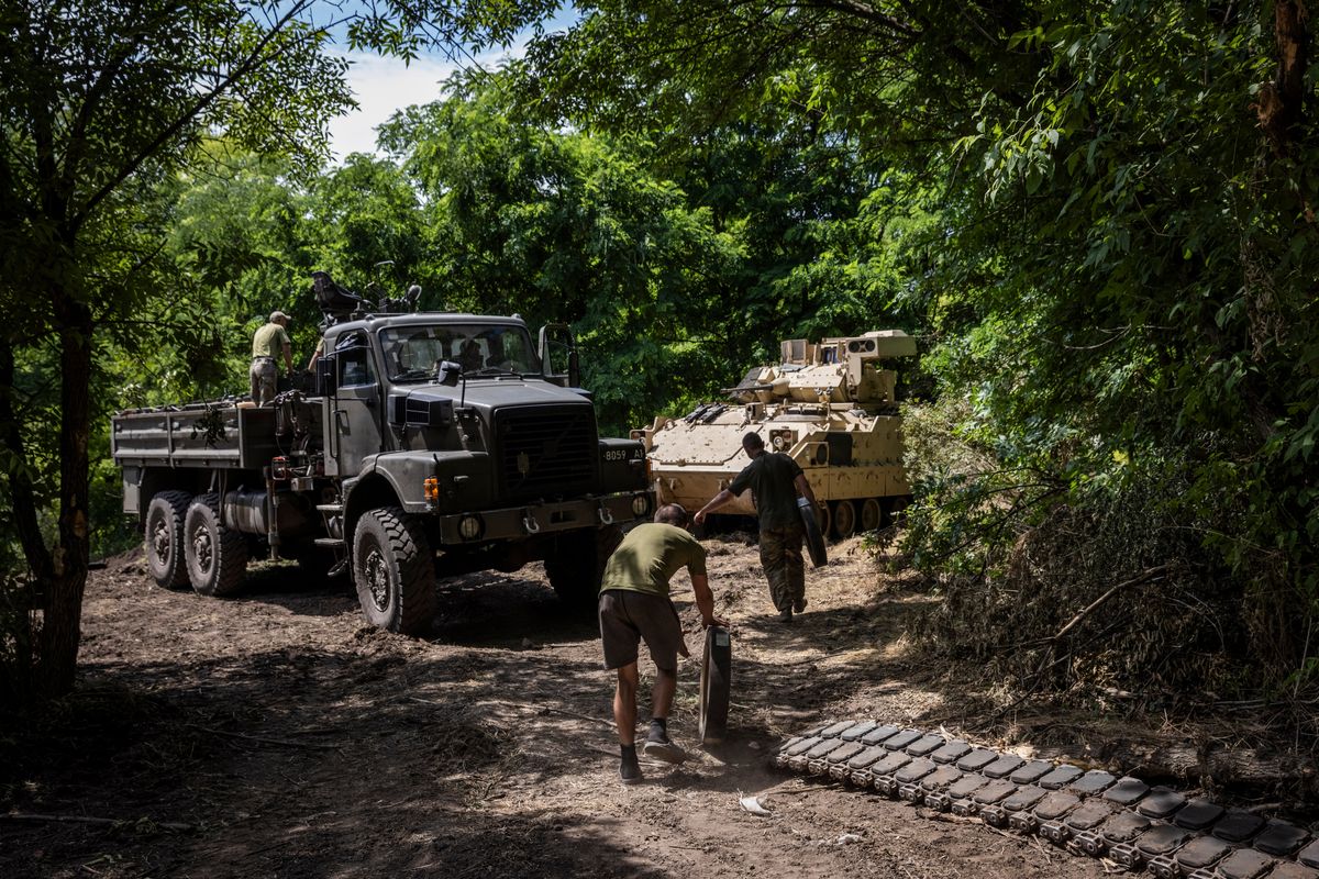 Personnel from Ukraine’s 47th Mechanized Brigade prepare to change wheels and tracks of a damaged Bradley Fighting Vehicle at the Zaporizhzhia workshop.  (Ed Ram/for The Washington Post)