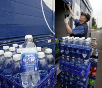
PepsiCo delivery man Nick Jones unloads Aquafina water and other Pepsi products while making a delivery in Tualatin, Ore. The label on Aquafina water bottles will soon be changed to spell out that the drink comes from the same source as tap water, the brand's owner PepsiCo said Friday. Associated Press
 (Associated Press / The Spokesman-Review)