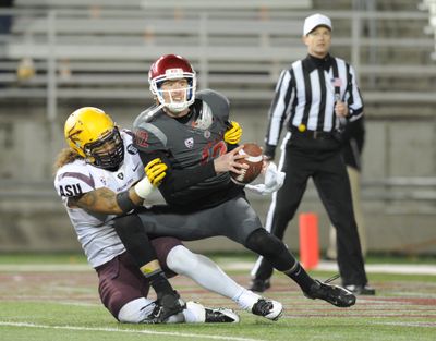 WSU quarterback Connor Halliday is grabbed by ASU’s Carl Bradford in front of plenty of empty seats Thursday night in Pullman. (Tyler Tjomsland)